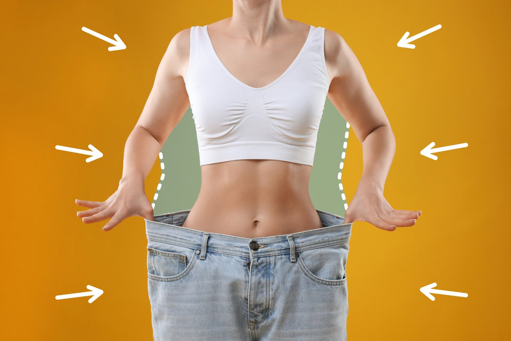 Patient after weight loss smiling confidently, showing a smooth, toned abdomen