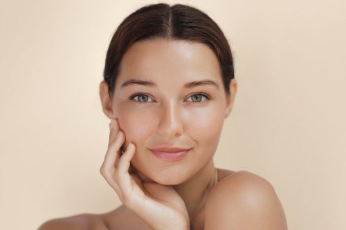Woman with subtle cosmetic enhancements in natural, elegant setting